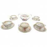Parte de jogo de café em porcelana marca Steatita, decoração floral guirlanda e frisos dourados, composto de um açucareiro sem tampa, cinco xícaras e seis pires. Apresenta bicado em uma xícara e três pires.