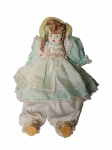 Colecionismo -Antiga boneca com mãos e rosto porcelana, pedestal em metal, com trajes típicos. Med. 40 cm.