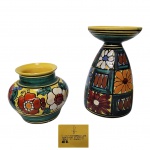 Dois vasos em cerâmica com bela policromia decorado com flores sobre fundo amarelo, marcado na base Cerâmica Bariloche - Argentina, apresenta leve restauro na borda do menor vaso. Med. Alt de 14 a 8cm e diam. 8cm.