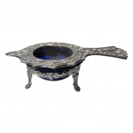 Antigo coador para chá em metal prateado e vidro na cor azul. Med. Alt. 3cm, 7 x12cm.