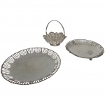 Terno de centro de mesa em metal espessurado a prata, bordas serrilhadas e frenestradas, duas sendo da marca Meridonal, uma cestinha com alça, Med. Diam. 23 a 15cm.