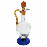 Licoreira em vidro com tampa, pegador e base coloridos nas tonalidades azul e amarelo. Medidas: Altura 34cm e Diâmetro 12cm.