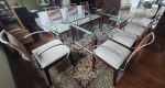 Mesa de jantar com 8 cadeiras, com tampo em vidro bisotado e estrutura em madeira e inox, cadeiras com assento em tecido e encosto com fios em couro. Obs: 1 cadeira necessita restauro no couro. Retirada pelo comprador. Medidas da mesa: 73 cm de altura, 1 m de largura e 2 cm de comprimento. Medidas da cadeira: 85 cm de altura, 52 cm de largura e 50 cm de comprimento.