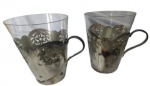 Par de copos em cristal com suporte e alça em metal espessurado a prata. Medidas: Altura 10cm Diâmetro 8cm.