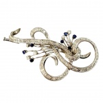 Broche em platina com brilhantes totalizando aproximadamente 1,10Ct de brilhantes e safiras totalizando aproximadamente 0,40Cts - Medindo:7x3cm - Peso:11,90Gr
