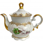 REAL - Bule para chá em porcelana REAL esmaltada fabulosamente adornada com ramalhete de flores em policromia e vibrante ouro. Acompanha a sua respectiva tive tampa com pega. Possui marca na base. Mede 23cm.