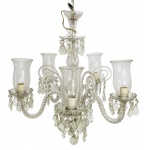 Imponente lustre de cristal translúcido com cinco braços curvos retorcidos no formato "s", que ostentam mangas com lapidações florais e bordas onduladas. Contem cinco "rabos de macaco" e bobeches com pingentes no formato diamante. Mede 70 x 60cm.