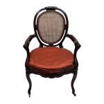 BRASIL SÉC. XIX - Cadeira de braços em jacarandá entalhado, acento e encosto vazado em telinha, pés frontais com rodinhas de metal. Original da época. Mede 1,03 x 65cm.