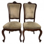 LUIS XV - Par de sofisticadas cadeiras de espaldar alto, estrutura em madeira nobre, estofamento em veludo alemão frente e verso. Florão no alto, saia em movimento, pés curvos para fora ao estilo francês LUIS XV. Muito bom estado. Mede 1,10cm altura x 45cm largura.