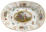 MEISSEN SÉC. XIX -  Secular travessa em pasta de porcelana dura alemã feita a mão, fabulosamente adornada com cena galante, flores e borboletas, borda recortada com friso em vibrante ouro. Possuiu registro MEISSEN no verso. Meados séc. XIX. Mede  28 x 39 cm.