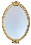 Antigo espelho de estilo francês em cristal bisotado, formato ovalado com proteção de moldura de madeira com acabamento em folha de ouro e entalhes de laçarotes. Mede 90 x 60cm.