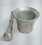 Antigo Almofariz em espesso alumínio fundido maciço com Pistilo. Medida: 10 cm de diâmetro de boca x 8 cm de altura. Medida do pistilo: 18 cm x 3 cm de diâmetro maior. Conforme fotos.