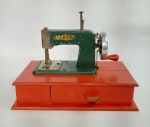 Antiga e Linda Mini Máquina de Costura à Manivela Infantil - BAMBI - Anos 50 - Estrutura em Metal, gabinete em madeira com gaveta. Manivela funcionando. Medida: 22 cm x 11,5 cm x 16 cm de altura. Obs: Possui uma trinca no gabinete, porém não compromete sua estrutura. Conforme fotos.