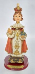 Di Angelo Fine Art  - Linda Imagem em Resina Representando - Menino Jesus de Praga - Base em Madeira - Medida: 21 cm de altura x 10 cm x 8 cm. OBS: Possui pequena perda de material em um dos dedos da mão que segura o Globo Crucífero. Conforme fotos.
