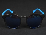 Óculos de sol retrô, armação azul e preta, lentes espelhadas.