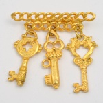 Broche dourado berloques de chaves. 5x5 cm