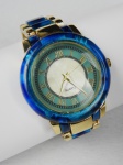 Vintage - relógio de pulso Quartz. Mostrador com fundo branco perolado e verde, números em romanos, ponteiros e numeração em dourado, caixa de acrilico azul turquesa medindo  (3,7 cm diam), pulseira  original dourada e azul, no mesmo padrão da caixa. Parado sem garantias futuras