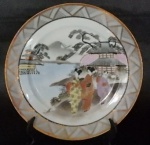 Prato ornamental oriental em porcelana policromada pintada a mão com cena oriental e bordas em ouro medindo 19 cm de diâmetro