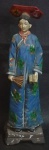 Estatueta chinesa em resina com rica policromia representando dignatária em traje típico, não direita um leque e na esquerda um livro. Alt. 23cm