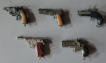 MINIATURAS DE REVÓLVERES.Lote com 5 miniaturas de revólveres diversos em metal e plástico.Dois marcados Victory. Maior com 6,5 cm