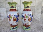 Par de vasos em porcelana chinesa com rica policromia e detalhes em alto relevo . Bordas onduladas. Marca de origem na base . medida - 21 cm.