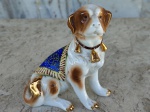 Esculttura em porcelana representando  cachorro. 11cm x 8 cm x 12 cm.