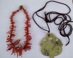 Duas peças de adorno pessoal : um colar de coral  em gravetos medindo 44 cm e uma grande  placa em JADE medindo 10 x 9 cm.