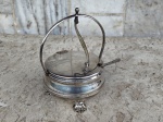 Açucareiro em metal espessurado a prata , tampa articulada . Interior  com recipiente no tom branco , tres pezinhos . Acompanha  colher graciosa para açucar .Marca de procedencia na base . medidas : altura 17 cm e circunferencia 10 cm .