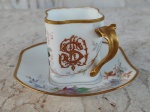 França /LIMOGES -  W.Guerin&C .  Linda xícara com pires de porcelana francesa , formato levemente quadrado , ramos de flores em fundo branco. Pega e borda  tanto da xícara como do pires cobertos de ouro . Circa de 1900. MONOGRAMADA  . Altura 6 cm.