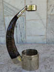 Suporte em ALPACA com material curvo que se assemelha a um chifre ou corno utilizado para manusear e facilitar o manuseio do vinho . Altura 21 cm . Não esta incluida a bebida .