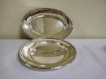 Duas travessas em metal espessurado a prata  uma redonda 27 cm e uma oval 32 x 22 cm.