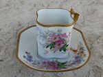 França /LIMOGES -  W.Guerin&C .  Linda xícara com pires de porcelana francesa , formato levemente quadrado , ramos de flores em fundo branco. Pega e borda  tanto da xícara como do pires cobertos de ouro . Circa de 1900. MONOGRAMADA .Altura 6 cm.