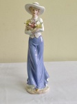 Escultura em porcelana  representando "dama florista". Altura 30 cm.