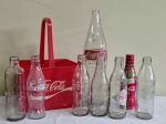 Lote contendo 8 (oito) antigas garrafas da COCA COLA , de diversas épocas , e todas em vidro exceto uma de plástico . Acompanha engradado de plástico  (30 x 21 cm ) Garrafas medem entre 20 e 37 cm.