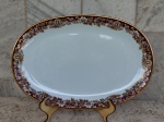 Travessa oval de  porcelana Renner de Porto Alegre , design Mon Cheri , branca  com bordas floridas no tom ocre e detalhes  em ouro brunido. Medidas 34 cm x 22 cm.