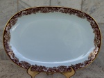 Travessa oval de  porcelana Renner de Porto Alegre , design Mon Cheri , branca  com bordas floridas no tom ocre e detalhes  em ouro brunido. Medidas 36 cm x 24 cm.