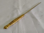 Interessante peça para abrir correspondências em metal dourado , com delicada gravação , no estilo Império , de folhagens e figura de mercúrio. Comprimento 24 cm.