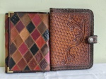 Duas CAPAS para guarda de conteúdo de escritório diverso . Ambas em couro pirografado. Medem 24 x 17 cm.