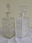 Duas garrafas em vidro moldado de diferentes modelos. Alturas 28 e 30 cm.