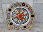 Prato decorativo em porcelana esmaltada e policromada com motivos e cenas chinesas  com marca no verso . Medidas  23 cm