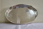 Bandeja  européia de metal prateado com galeria alta tendo ao fundo gravação em baixo relevo de folhagens  e arabescos . Quatro pezinhos. medidas 40 x 31 x 8 cm