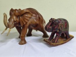Duas esculturas em madeira representando  "elefantes " . Um no balanço e outro em madeira clara .  33 x 23 x 19 cm  e 19 x 8 x 16 cm. O maior apresenta insignificantes bicadinhos.