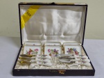 SALER : conjunto de seis pratinhos e seis faquinhas em porcelana com rica decoração de flores policromadas . Na caixa original.  CX 17 x 27 cm
