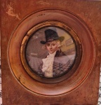 Pintura a óleo de miniatura colorida, provável francesa, de retrato circular de 7cm de diâmetro de jovem caçador com cartola alta  .Moldura antiga em madeira medindo 14 x 12 x 2 cm. Não encontrada assinatura.