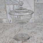 Compoteira em cristal translúcida ,estilosa , alta , medindo 25 cm de altura e boca com diâmetro de 15 cm.