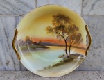 Recipiente com pintura de paisagem campestre e alças laterais cobertas com ouro .Diâmetro 24,5 cm e altura 6 cm .  marca da porcelana na base.