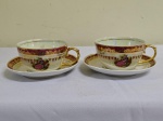 PAR DE XÍCARAS grandes para chá em porcelana carnival glass com frisos em ouro e pintura de cena galante ao centro . Alças cobertas de ouro. Boca da xícara 10 cm , altura 5,5 cm e pires 15 cm.