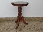 Mesa auxiliar redonda em madeira nobre com tres pés medindo 66 cm de altura e 45 cm de diâmetro.