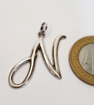Pingente produzido em prata de lei, com representação de letra N, maior comprimento:3,8cm.
