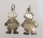 Lote contendo dois pingentes produzidos em prata de lei, com representação de meninos, maior comprimento:2,7cm.